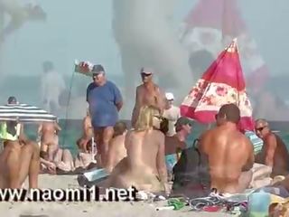 Naomi1 drkanje a mlada chap na a javno plaža